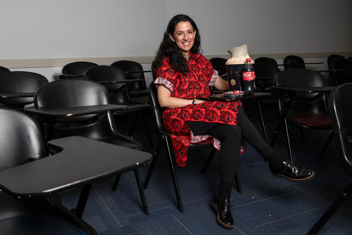 Professor Elisabeth Anker sits with a “Dune: Part Two” popcorn bucket and other movie snacks.