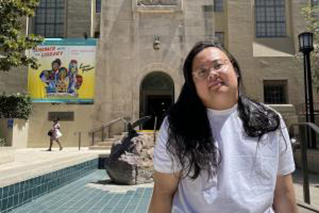PhD student GJ Sevillano sitting in front of the LA Central Library during a recent research trip in California.
