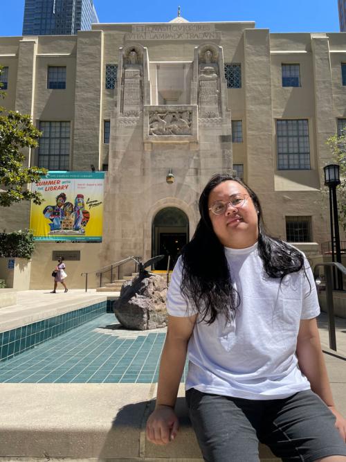 PhD student GJ Sevillano sits in front of a library during a recent research trip in California